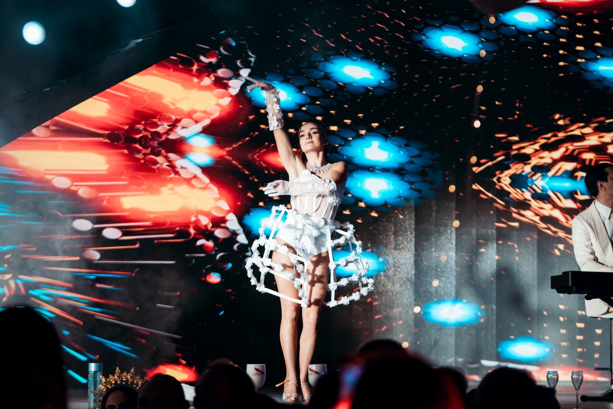 A dancer and a keyboard player on stage before a sparkling LED wall
