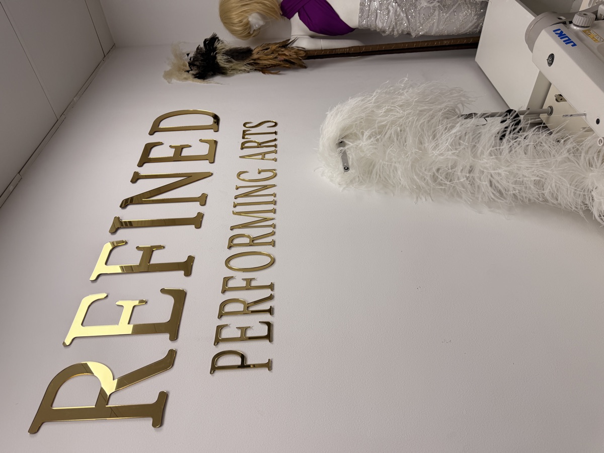 The atelier with brand lettering, a mannequin in sequin fabric and a feathered headdress