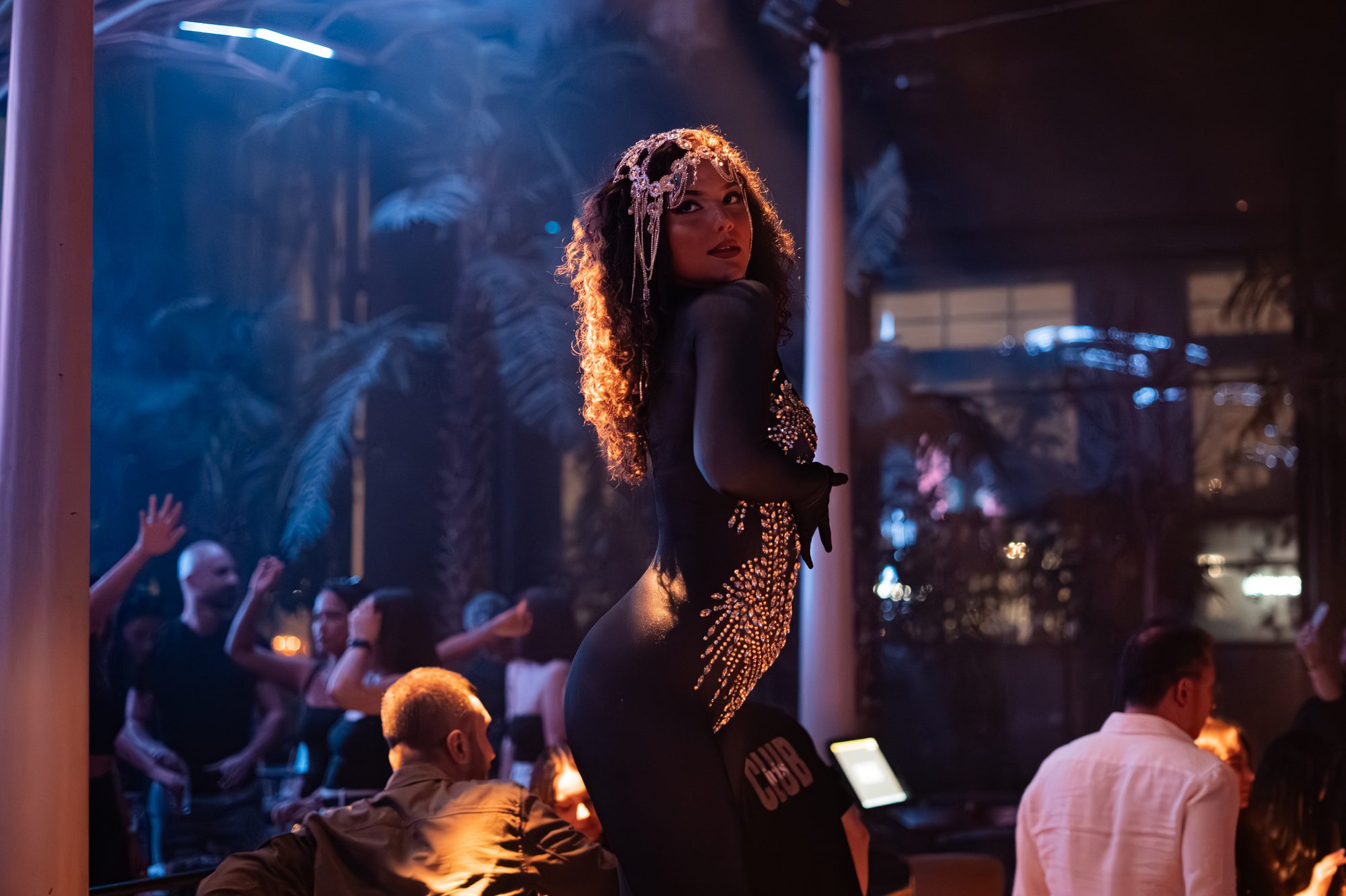 A Refined performer in a beaded costume on stage during a club show