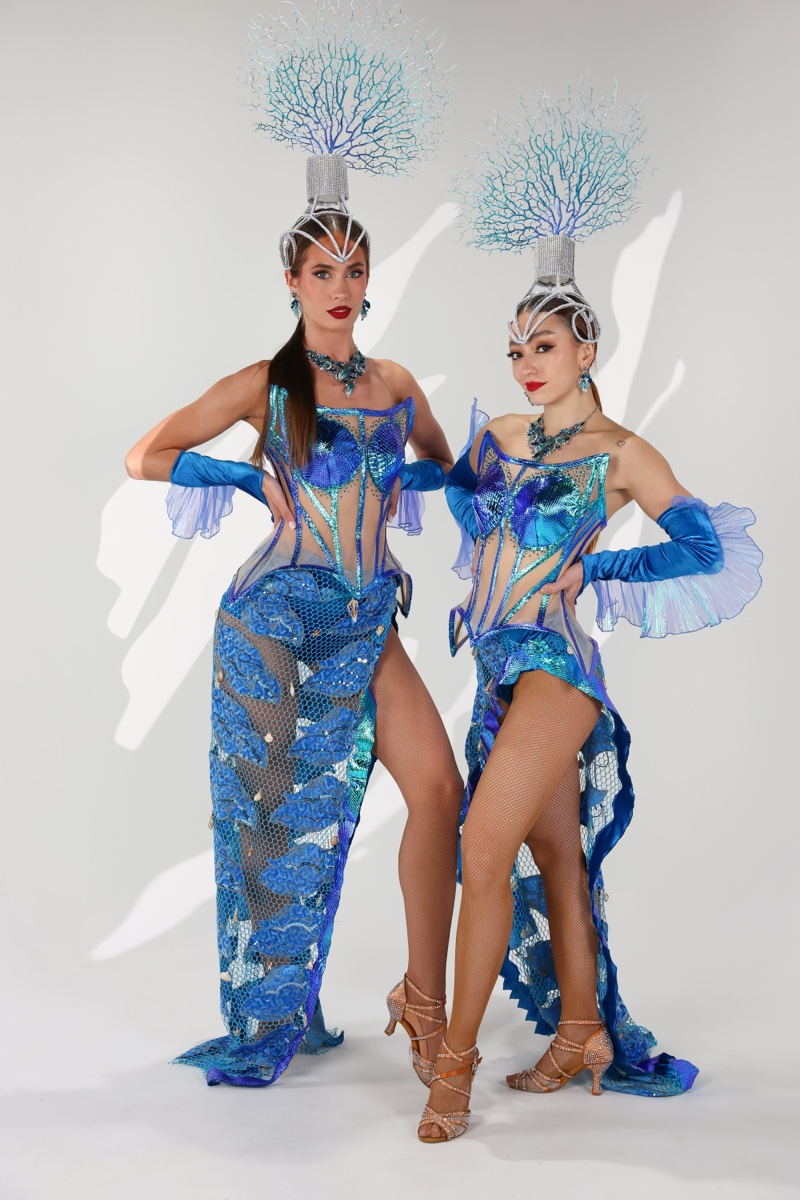 Two performers wearing the finished Ocean Collection costumes in blue sequin with coral headpieces