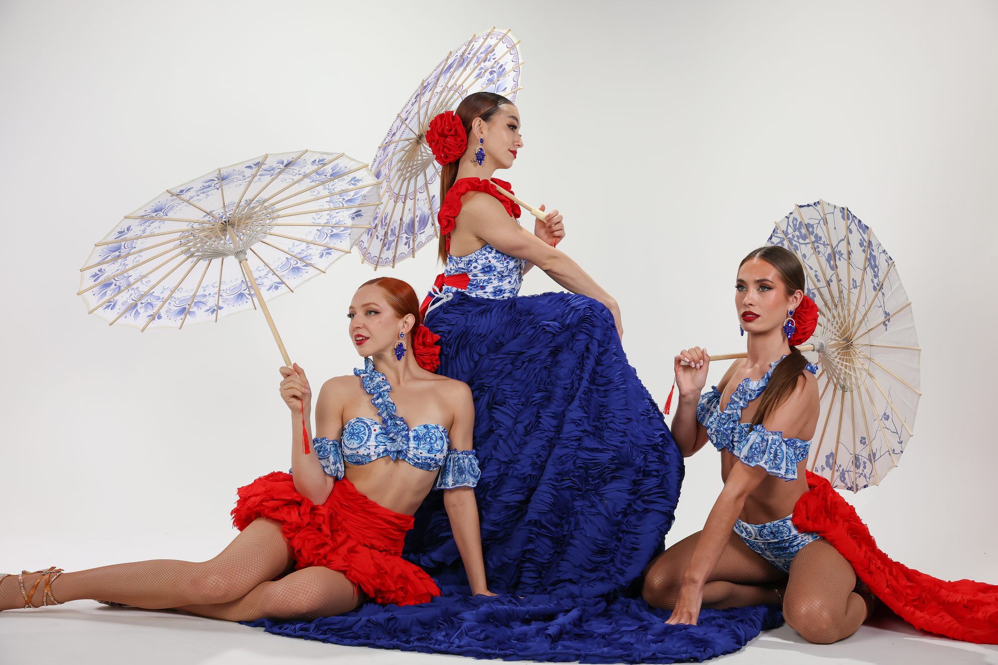 Two Refined dancers in blue and red costumes holding parasols