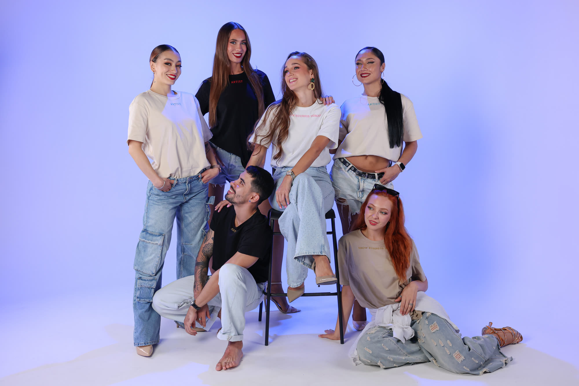 The Refined team together in the studio, in everyday clothes against a blue lit backdrop