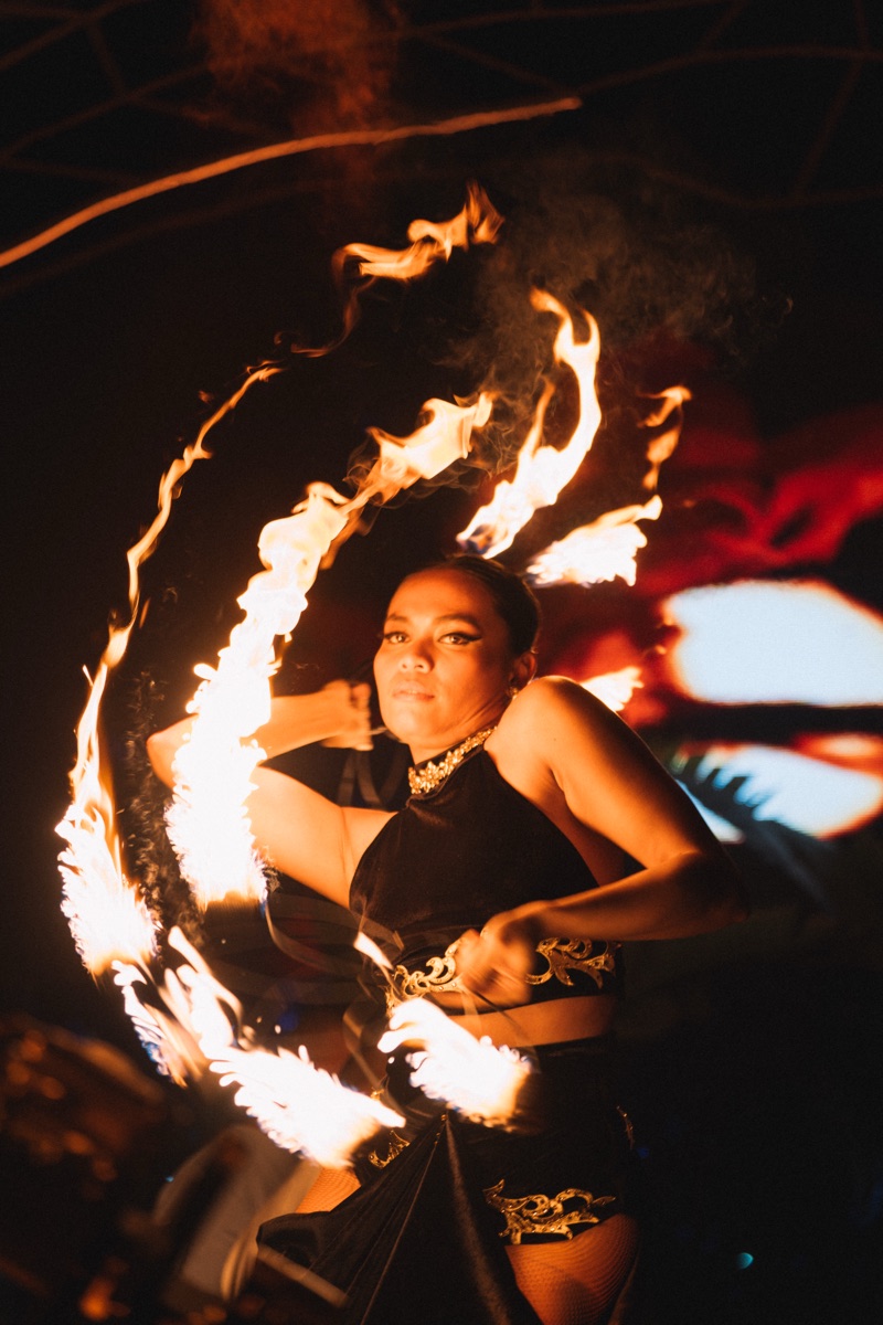 A fire dancer spinning an arc of flame around herself