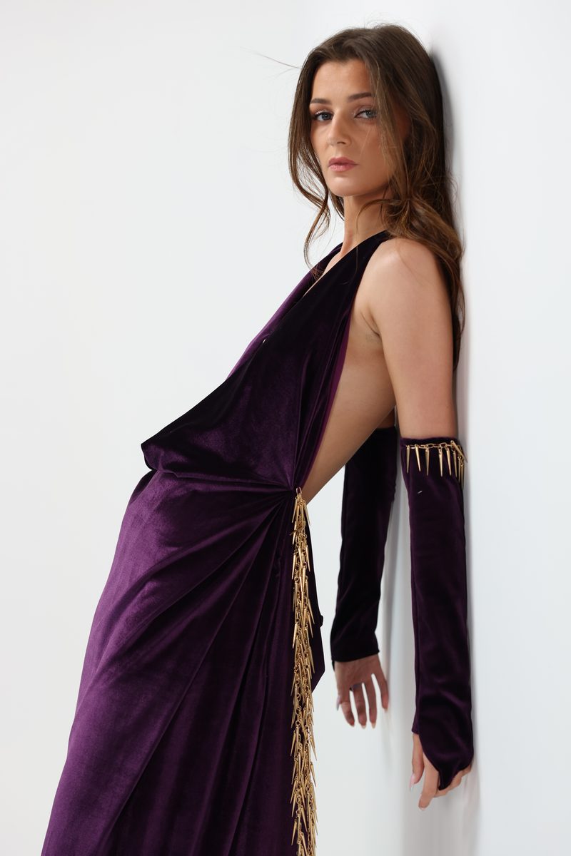 A performer in a purple velvet gown with gold trim
